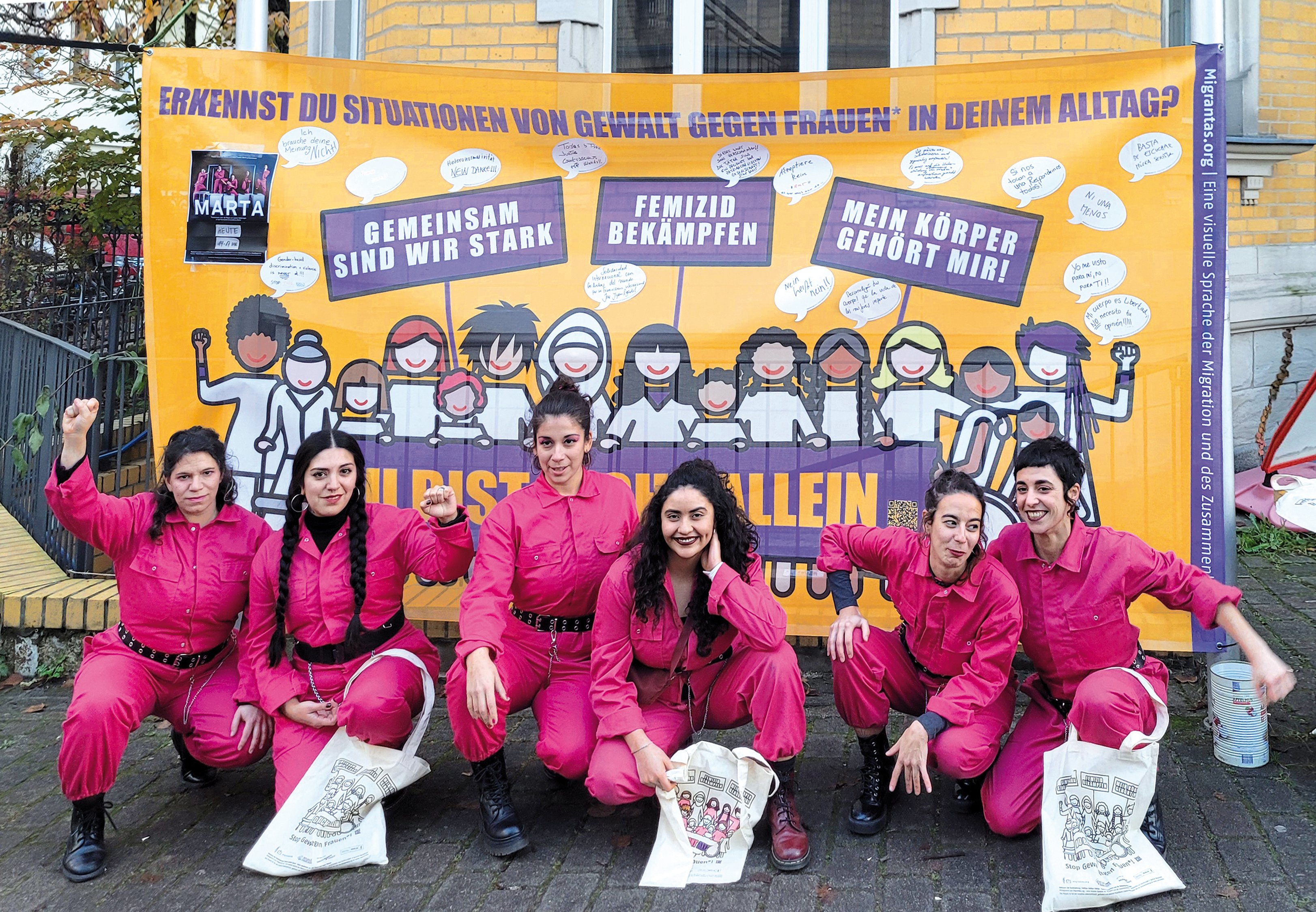 6 Frauen hocken vor einem orangenen Plakat mit lilaner Schrift. Auf diesem steht Erkennst du Situationen von Gewalt gegen Frauen* in deinem Alltag? Und darunter: Gemeinsam sind wir stark und Femizid bekämpfen