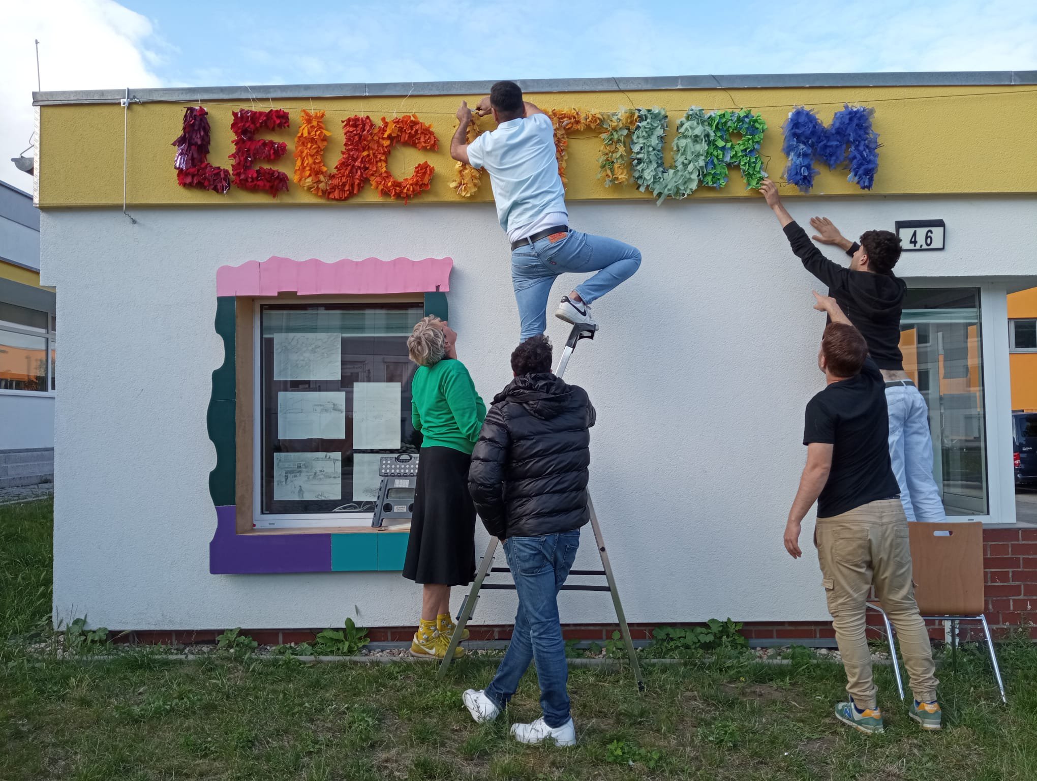 Aufhängung des Namens des Projekts mit den Jungen aus der Gemeinschaft Unterkunft
