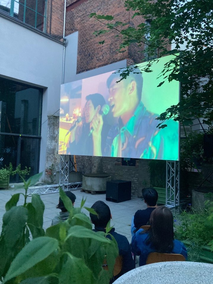 Ein Foto der Leinwand des Open Air Kinos auf dem ein Film läuft.